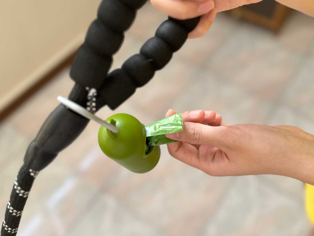 Pulling out a piece of dog poop bag from its container